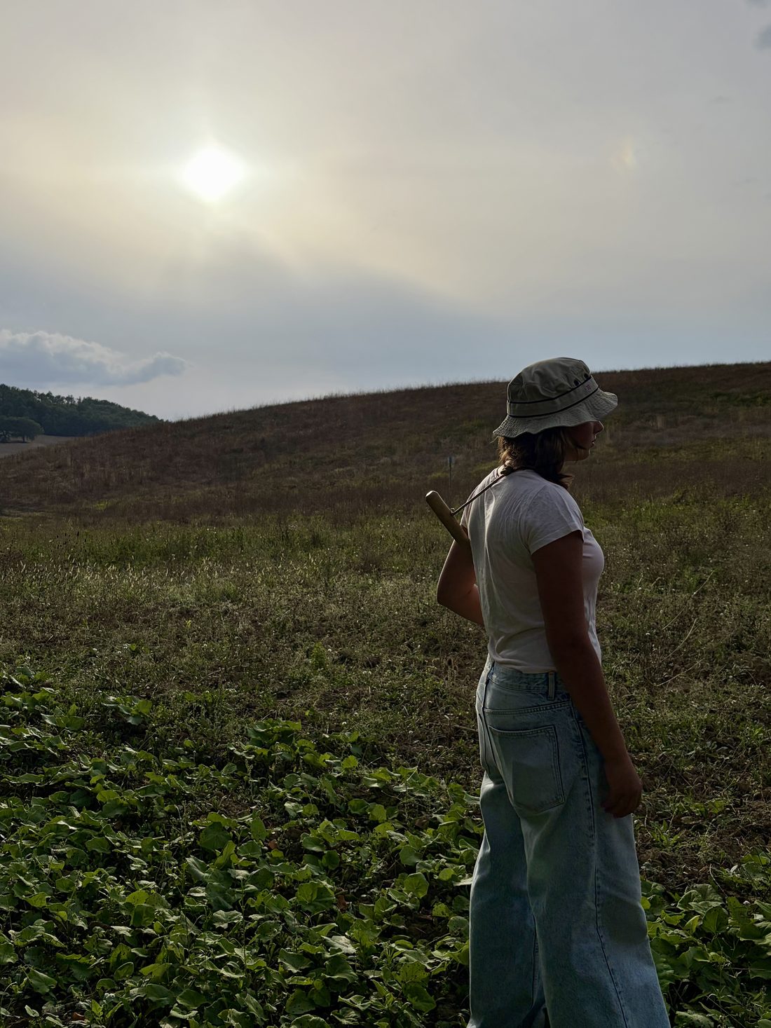Una partecipante nel campo, con il vanghetto in spalla